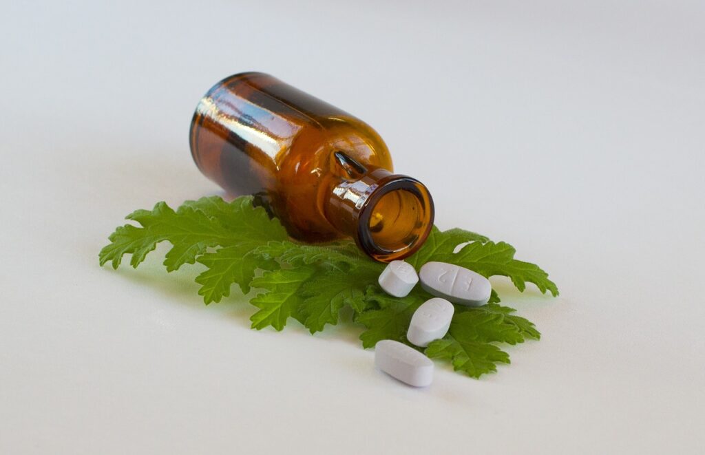 plant medicine leaves under bottle with pills