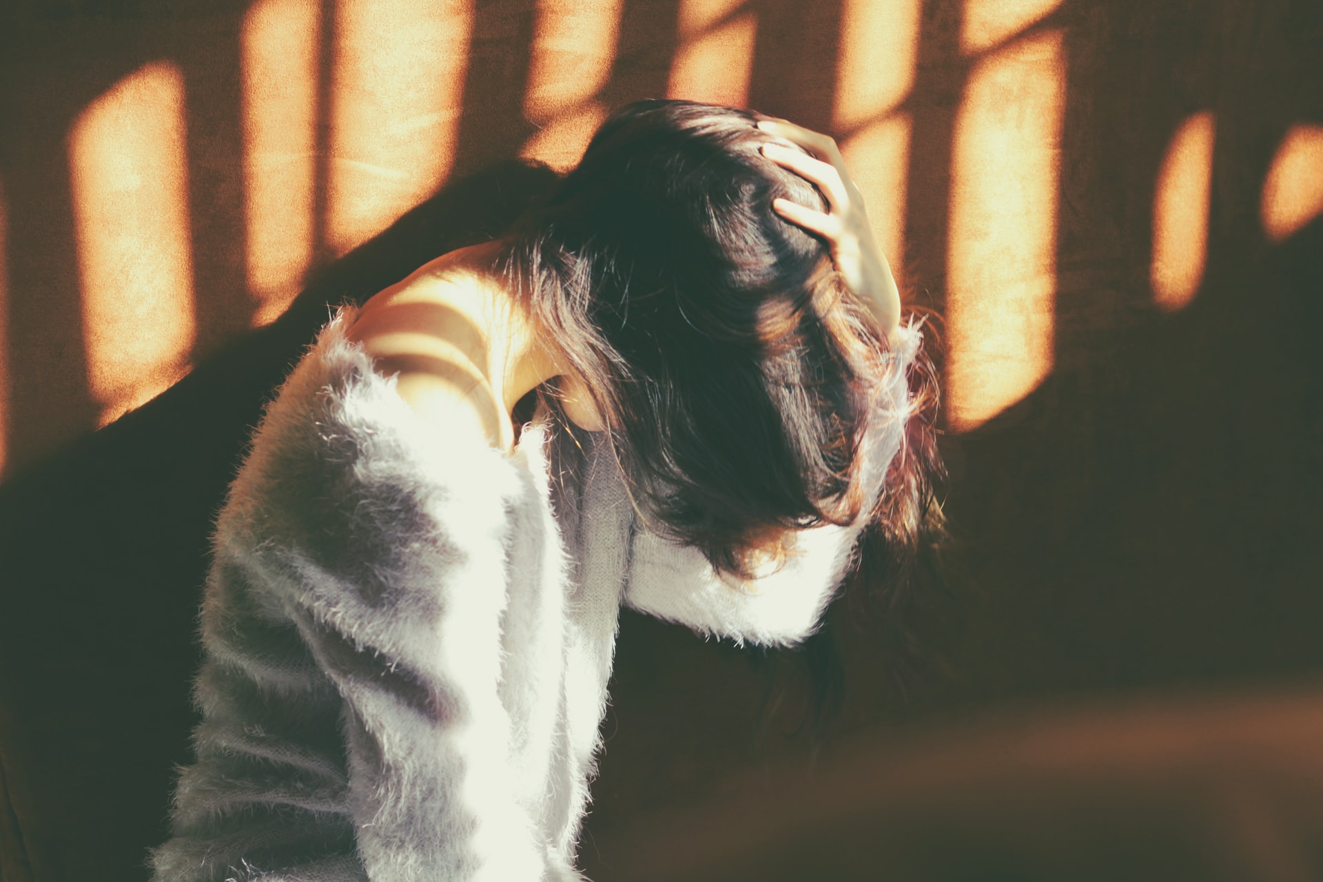 Woman with migraine holding hand on head