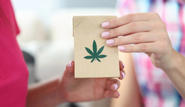 Female hands hold package featuring hemp leaf