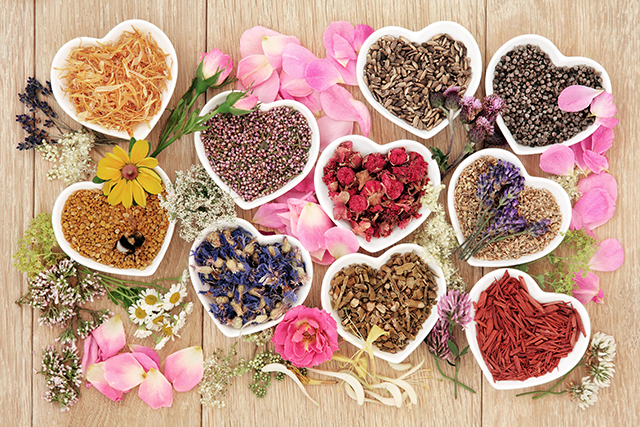 Herbs and flowers used in herbal medicine in heart shaped bowls