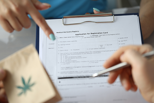 Woman holding medical marijuana card form