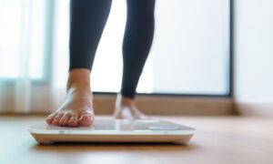 woman checking scale for zepbound weight loss results