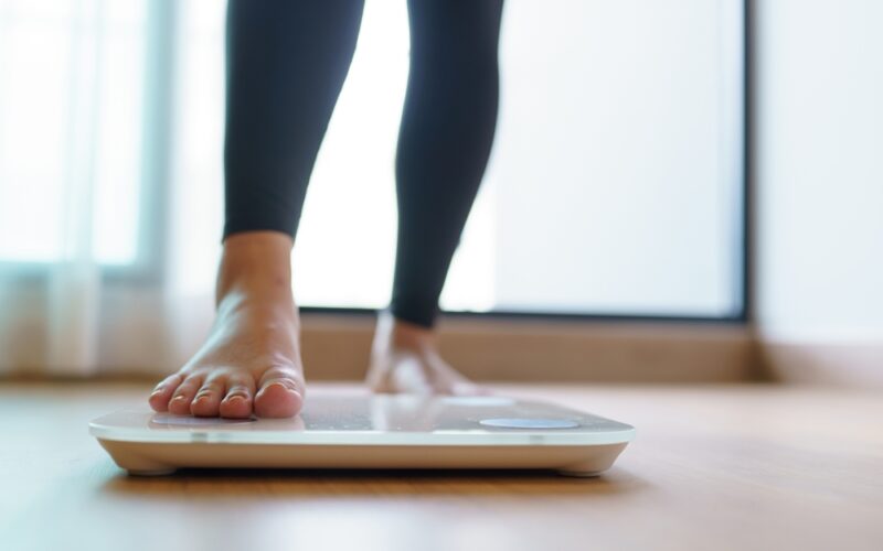 woman checking scale for zepbound weight loss results