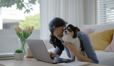 Young woman cuddling her dog as she sits in her home