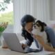 Young woman cuddling her dog as she sits in her home