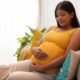 Happy Pregnant woman touching her belly and smiling