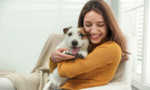 Woman cuddling her Emotion Support Animal in her home