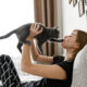 Woman playing with her Emotional Support Cat in her bed