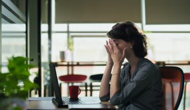 Woman sitting at her laptop dealing with fatigue