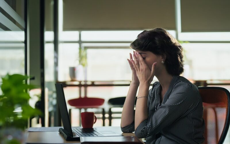 Woman sitting at her laptop dealing with fatigue