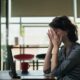 Woman sitting at her laptop dealing with fatigue