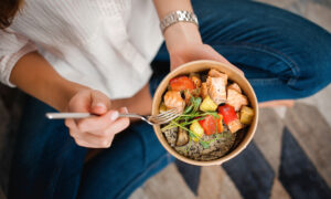 Woman eating a healthy meal with good protein and veggies