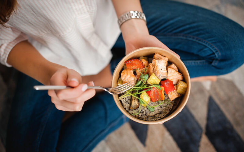 Woman eating a healthy meal with good protein and veggies