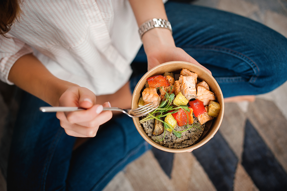 Woman eating a healthy meal with good protein and veggies