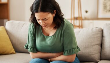 Woman sitting on her couch dealing with nausea