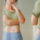 Woman standing in front of mirror unhappy with her weight