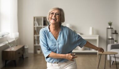 Happy older woman energized and dancing in her home