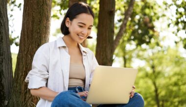 Young happy woman on laptop in the park