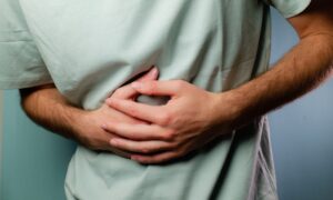 Young man holding his stomach in pain