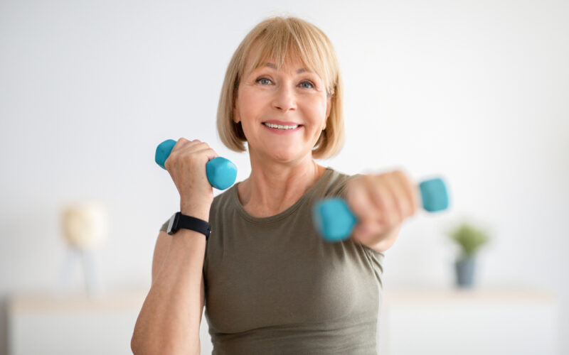 Older woman smiling and doing a home exercise