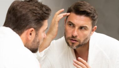 Man fixing his hair in the bathroom mirror