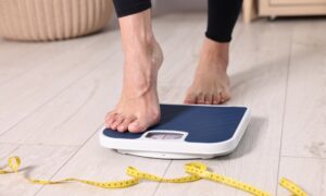 Woman stepping on scale to check weight