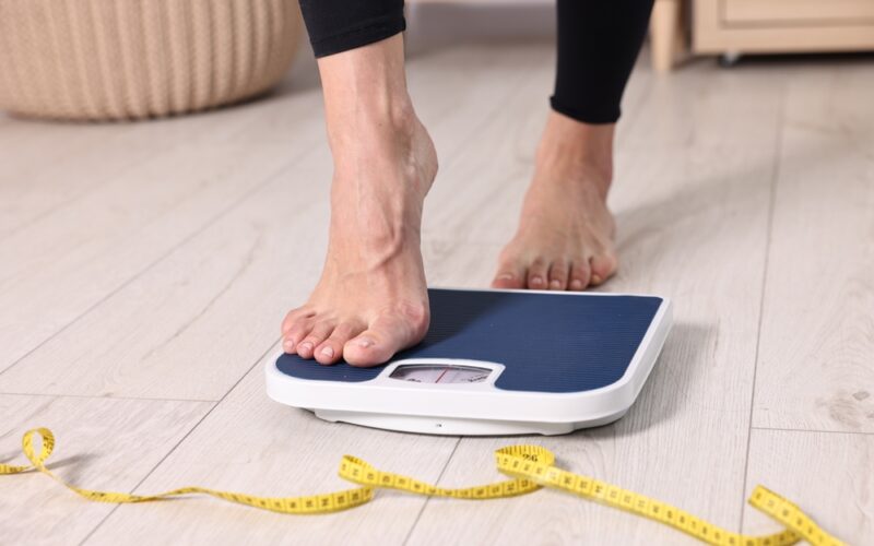 Woman stepping on scale to check weight