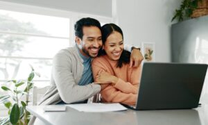 Happy couple sitting at computer