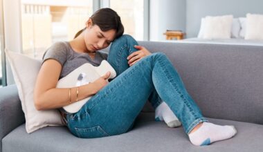 Woman laying on couch dealing with stomach pain
