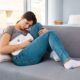 Woman laying on couch dealing with stomach pain