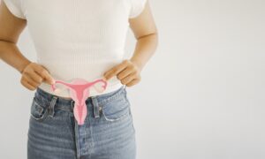 Woman holding up a uterus model