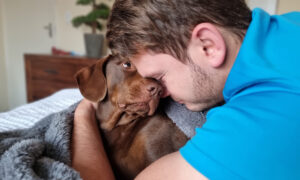 Man giving his dog a hug