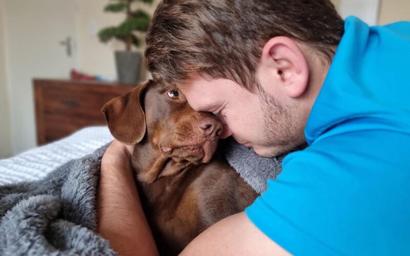 Man giving his dog a hug