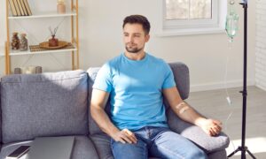 Man sitting on couch receiving IV therapy
