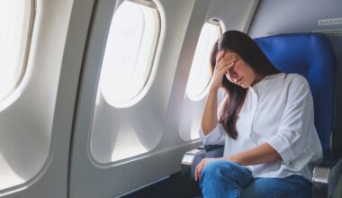 Woman feeling sick and tired while sitting on airplane