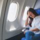 Woman feeling sick and tired while sitting on airplane