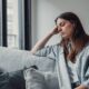 Up close shot of sad woman sitting on couch
