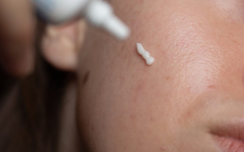 Close up of woman applying prescription cream to face