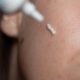 Close up of woman applying prescription cream to face