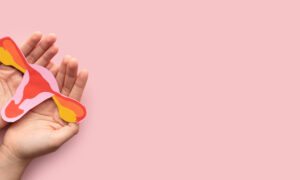 Woman holding a uterus shaped model made from paper