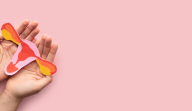 Woman holding a uterus shaped model made from paper