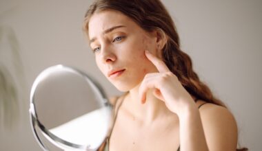 Woman looking at her skin and acne in a small mirror