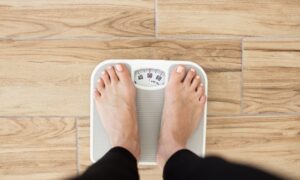 Close up of someone standing on a scale and weighing themselves