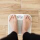 Close up of someone standing on a scale and weighing themselves