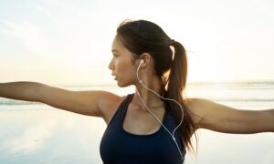 Woman with earphones in doing yoga and experiencing mental clarity