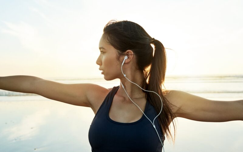 Woman with earphones in doing yoga and experiencing mental clarity