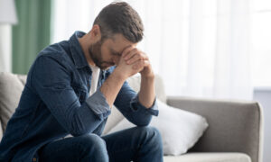 Depressed middle aged man sitting on the couch
