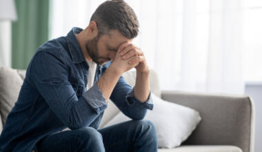 Depressed middle aged man sitting on the couch