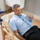 Man laying back receiving vitamin IV therapy and holding a glass of water