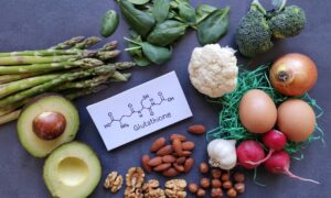 Foods shown that are rich in glutathione alongside a card that has glutathione written down